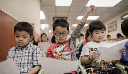 petits élèves asiatiques à l'école qui apprennent l'anglais